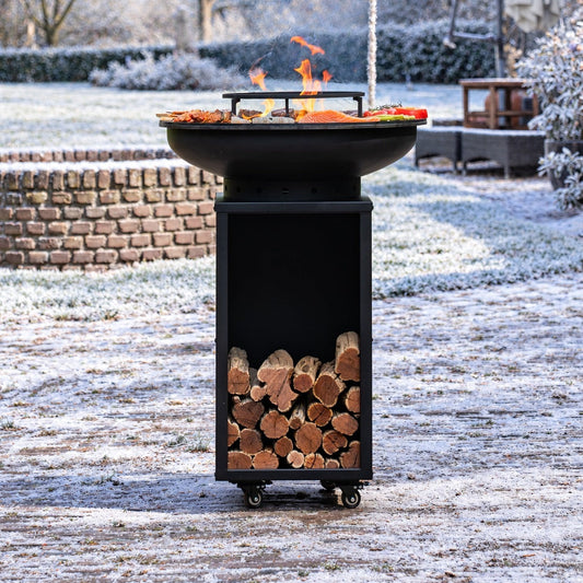 BBQ Plancha Grill Blackline Camarada 2.0 - Avec tisonnier et rangement bois Ø70cm — ambiance hivernale