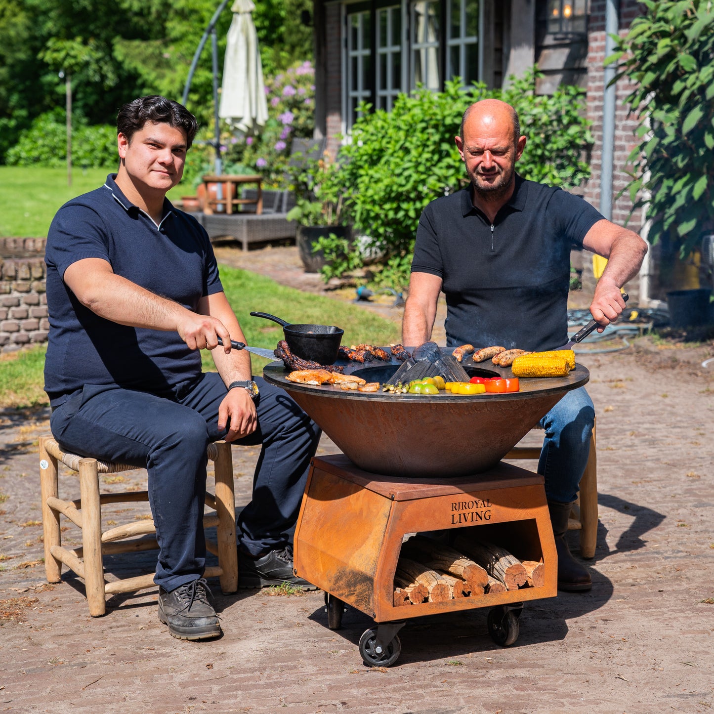Barbecue Plancha Grill Brasero en acier Corten avec grandes roues, rangement pour le bois et plaque de cuisson Ø80cm