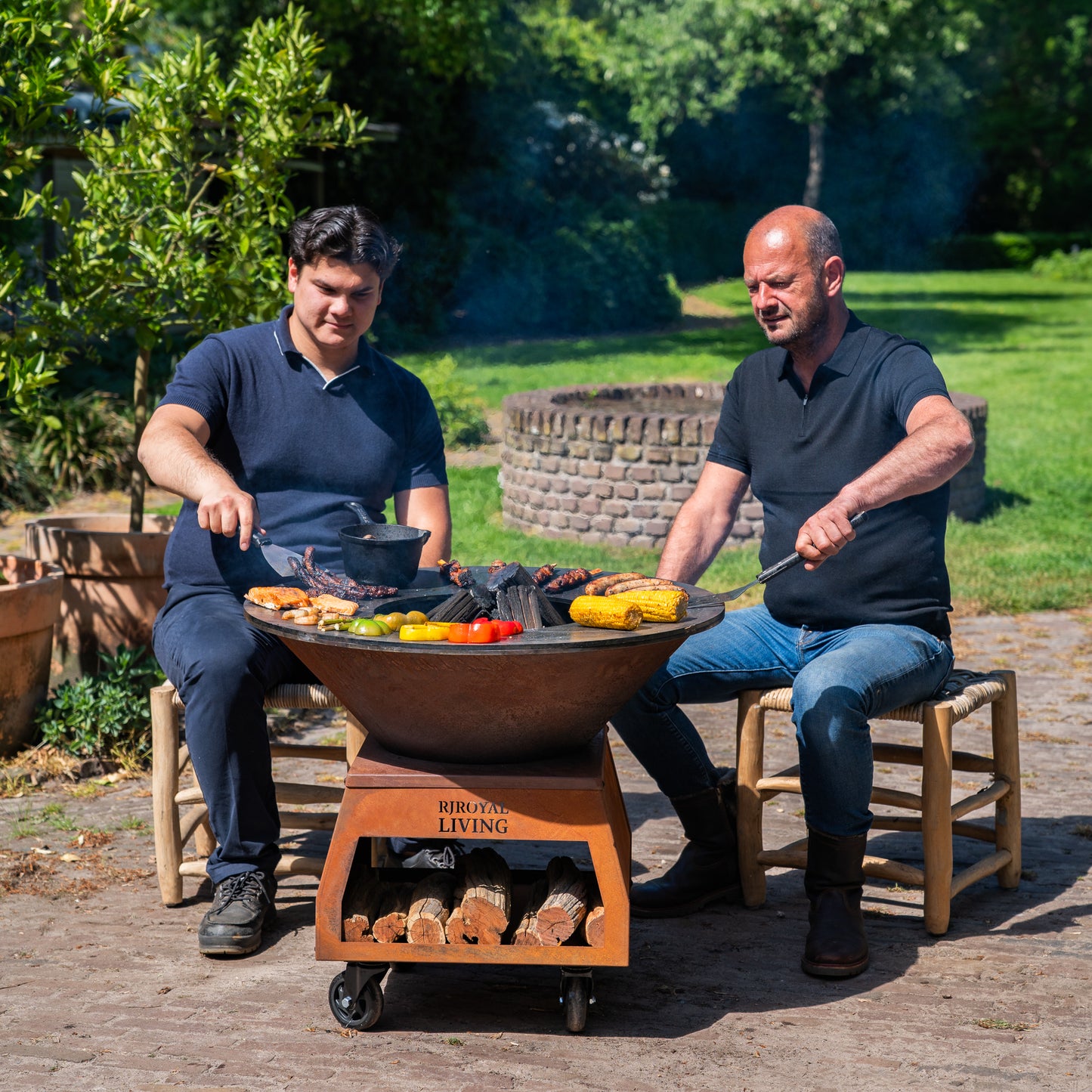 Barbecue Plancha Grill Brasero en acier Corten avec grandes roues, rangement pour le bois et plaque de cuisson Ø80cm