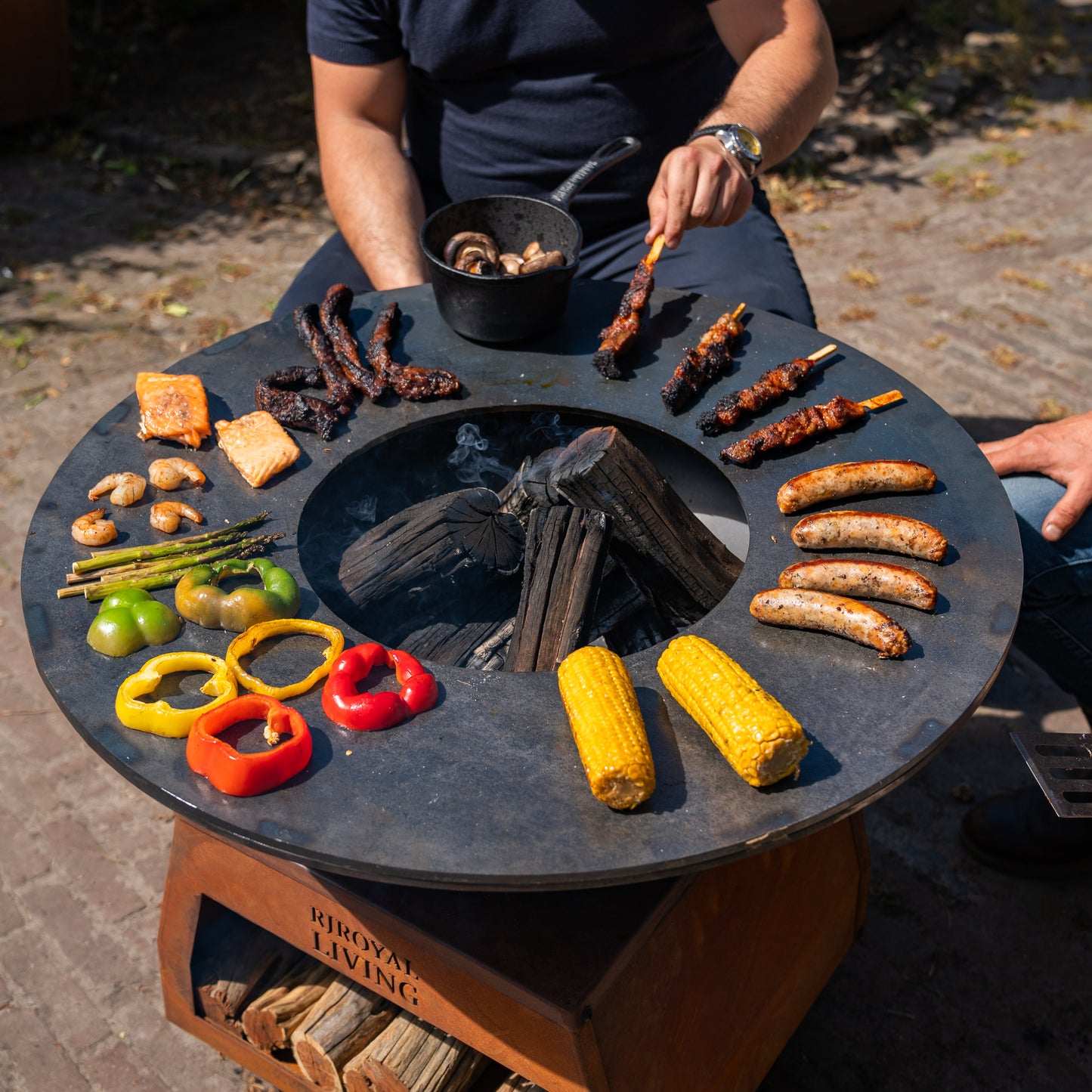Barbecue Plancha Grill Brasero en acier Corten avec grandes roues, rangement pour le bois et plaque de cuisson Ø80cm