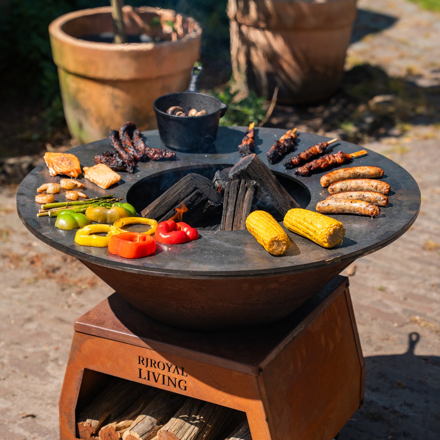 Barbecue Plancha Grill Brasero en acier Corten avec grandes roues, rangement pour le bois et plaque de cuisson Ø80cm