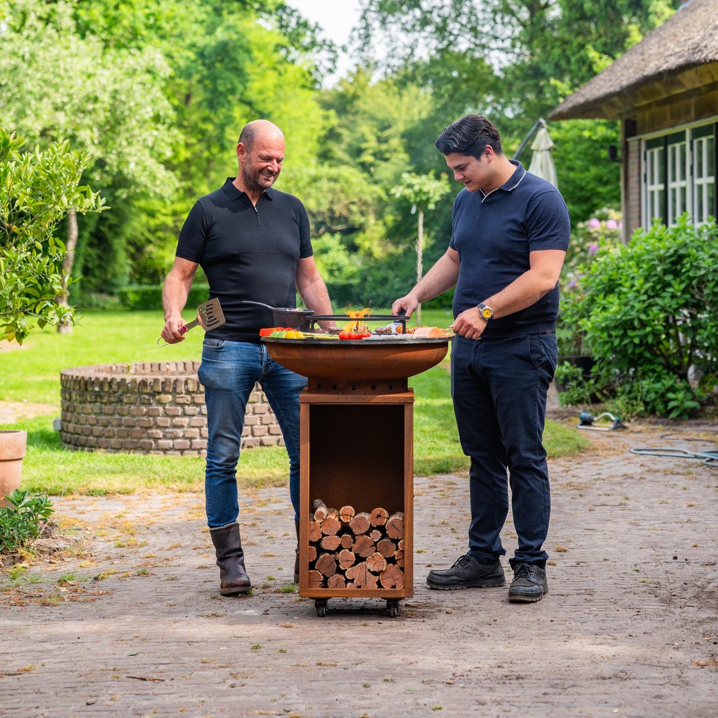 BBQ Plancha Grill Acier Corten Camarada 2.0 - Avec tisonnier et rangement bois Ø70cm